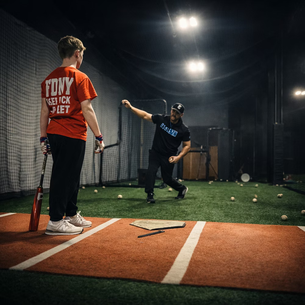 Coach Steve coaching a young hitter at home plate during a live training session
